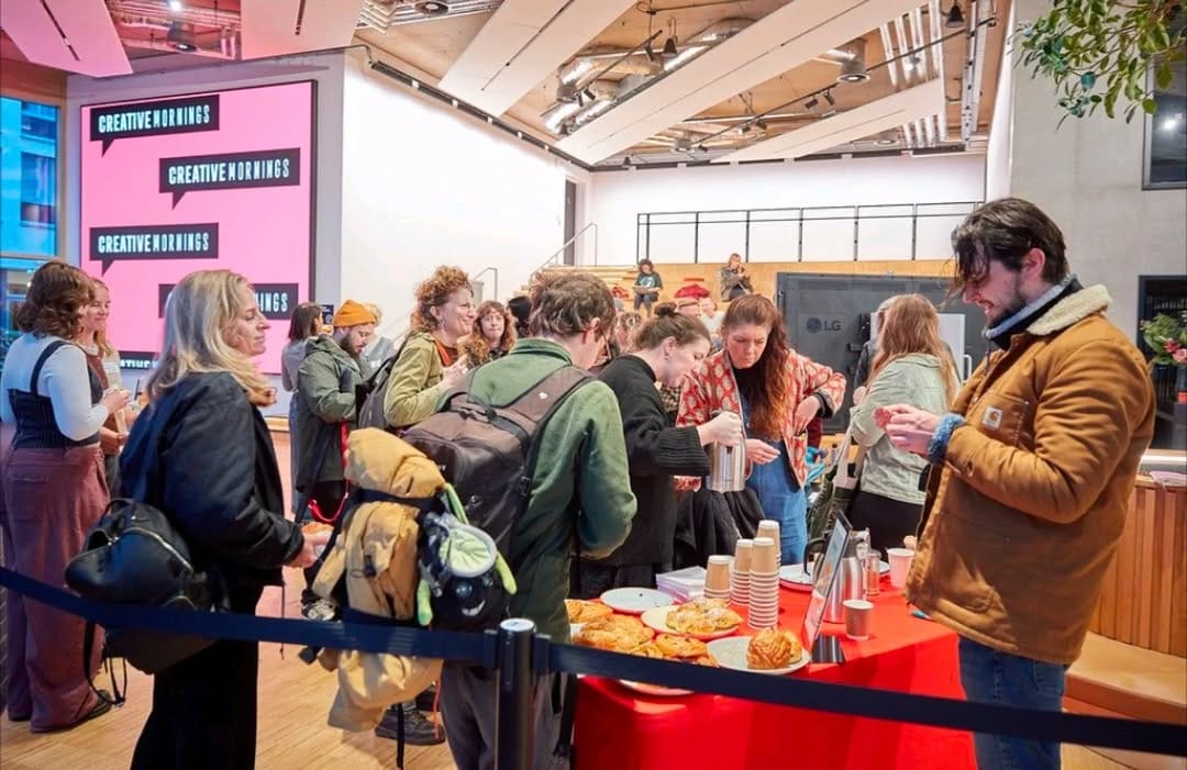 Creatives gather round with coffee in an events space.